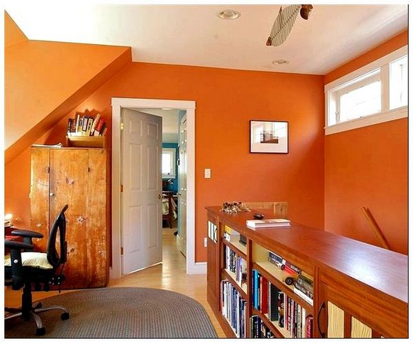 Яркие оранжевые стены в деревенском домашнем офисе.