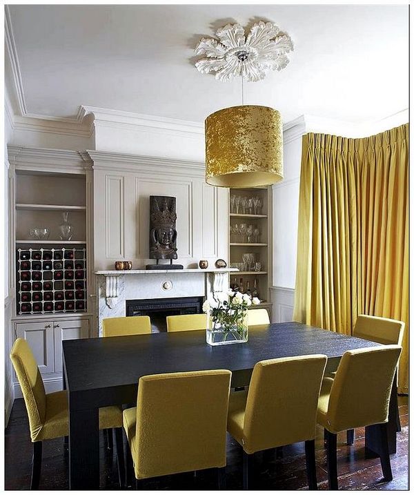Подвесной светильник, стулья и портьеры желтого цвета в интерьере столовой.